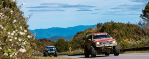 offroading cars driving with a mountain in the background