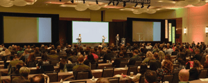 group of attendees watching a corporate conference presentation