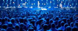 attendees watch speaker onstage at a corporate conference