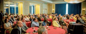 group of event attendees watching a presentation at a corporate conference