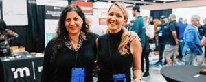 two event attendees smiling at a trade show expo