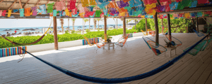 a hammock in front of chairs that sit next to the beach in Mexico, a favorite location for incentive trips