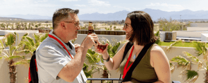 two incentive trip attendees enjoying a glass of wine at event check-in